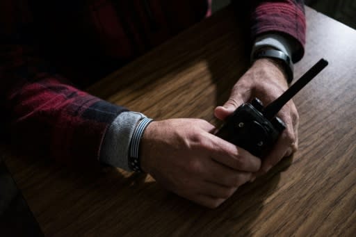 A trained and armed Sidney High School teacher, who keeps his identity concealed as part of the program, holds a walkie-talkie to be used for communication in case an active shooter threatens the school