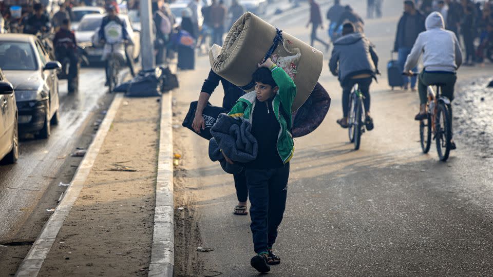 Palestinians carry belongings as they move to safer areas following the resumption of Israeli strikes on Rafah, in the southern Gaza Strip on Friday. - Mahmud Hams/AFP/Getty Images