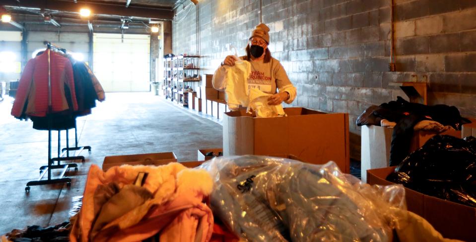 Mary O'Connor of South Milwaukee looks through a box of children's clothing for a specific size on Thursday, Jan. 20. She has been volunteering with Team Rubicon since August.