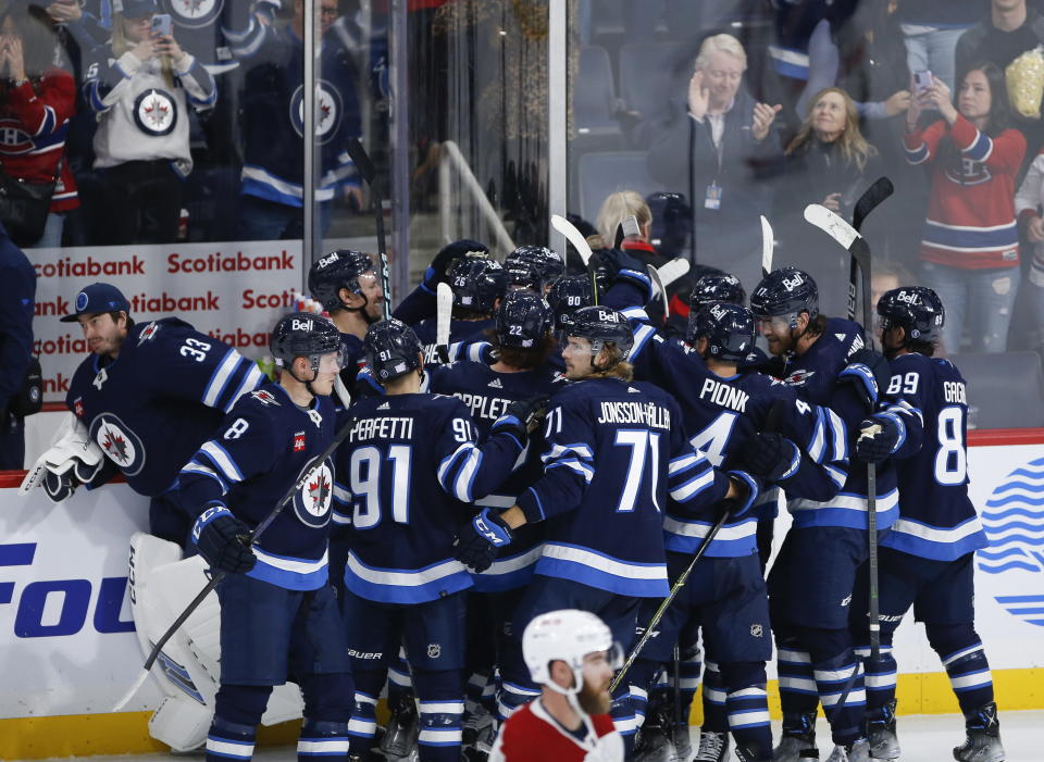 Winnipeg Jets players celebrate their overtime win against the Montreal Canadiens during an NHL hockey game Thursday, Nov. 3, 2022, in Winnipeg, Manitoba. (John Woods/The Canadian Press via AP)