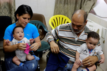 Joel Martinez and his daughter Cristina carry her sons Manuel and Miguel at the Concepcion Palacios Hospital in Caracas, Venezuela September 13, 2018. Picture taken September 13, 2018. REUTERS/Marco Bello