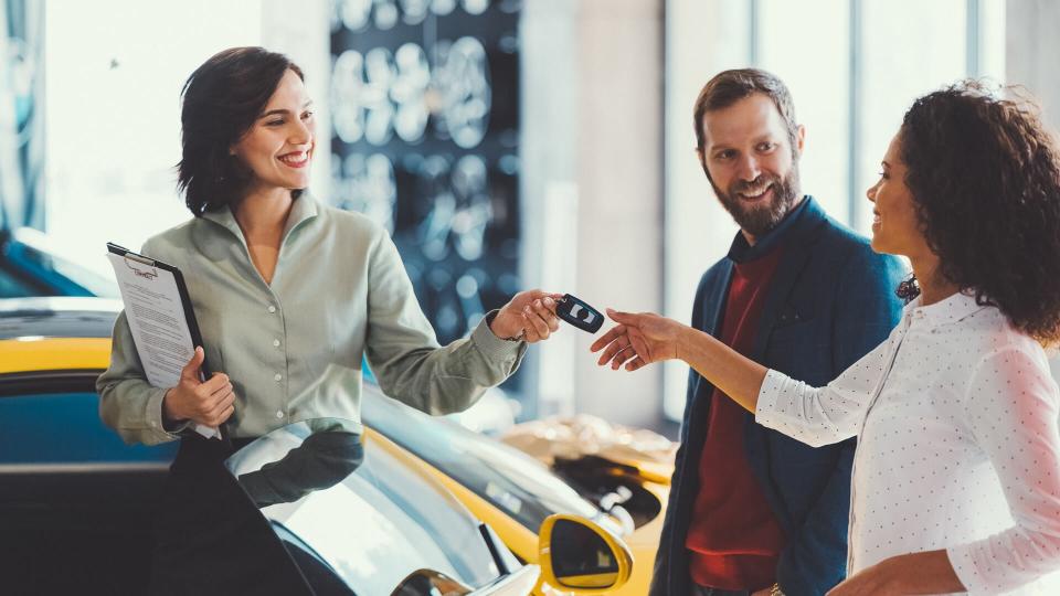 Young man surprising his wife with buying a new car.