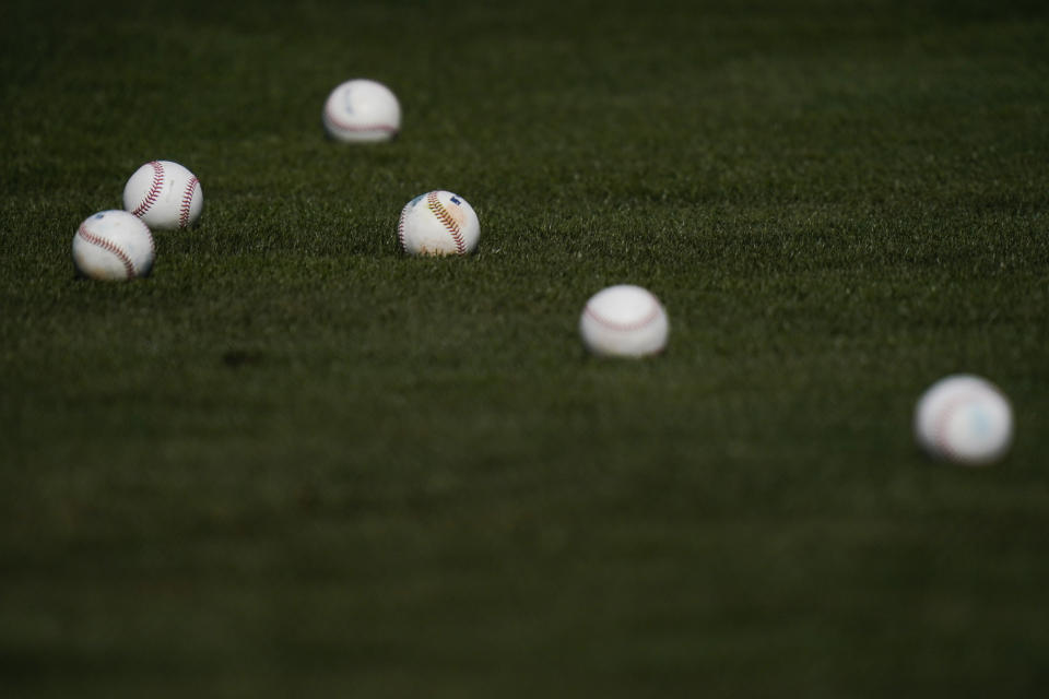 Batting practice balls are scattered on the field during the Arizona Diamondbacks' spring training baseball workout in Scottsdale, Ariz., Thursday, Feb. 25, 2021. (AP Photo/Jae C. Hong)