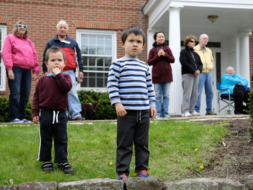<p>Brothers Samuel, 4, center, and George Thorpe, 2, watch with others as workmen cut up pieces of a large oak tree in Basking Ridge, N.J., Monday, April 24, 2017. Crews at the Basking Ridge Presbyterian Church in Bernards began taking down the 600-year-old tree that was declared dead after it began showing rot and weakness over the last couple of years. The tree has been an important part of the community since the town’s inception in the 1700s. (AP Photo/Seth Wenig) </p>