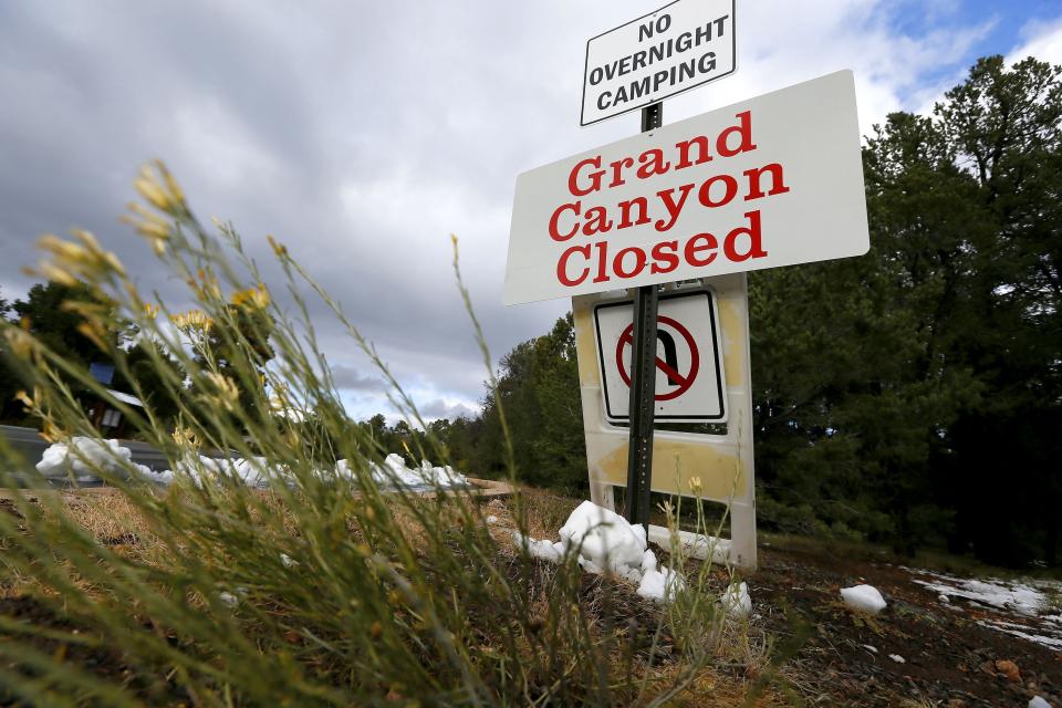FILE - The main entrance to Grand Canyon National Park remains closed to visitors in Grand Canyon, Ariz., due to the government shutdown, in October 2013. Arizona's Grand Canyon National Park and all five national parks in Utah will remain open if the U.S. government shuts down, Sunday, Oct. 1, 2023. Arizona Gov. Katie Hobbs and Utah Gov. Spencer Cox say that the parks are important destinations and local communities depend on dollars from visitors. (AP Photo/Ross D. Franklin, File)