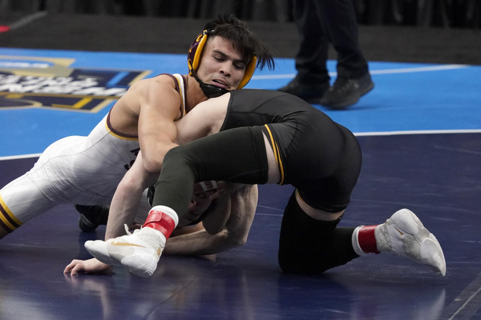 Iowa's Spencer Lee, right, takes on Arizona State's Brandon Courtney during their 125-pound match in the finals of the NCAA wrestling championships Saturday, March 20, 2021, in St. Louis. (AP Photo/Jeff Roberson)