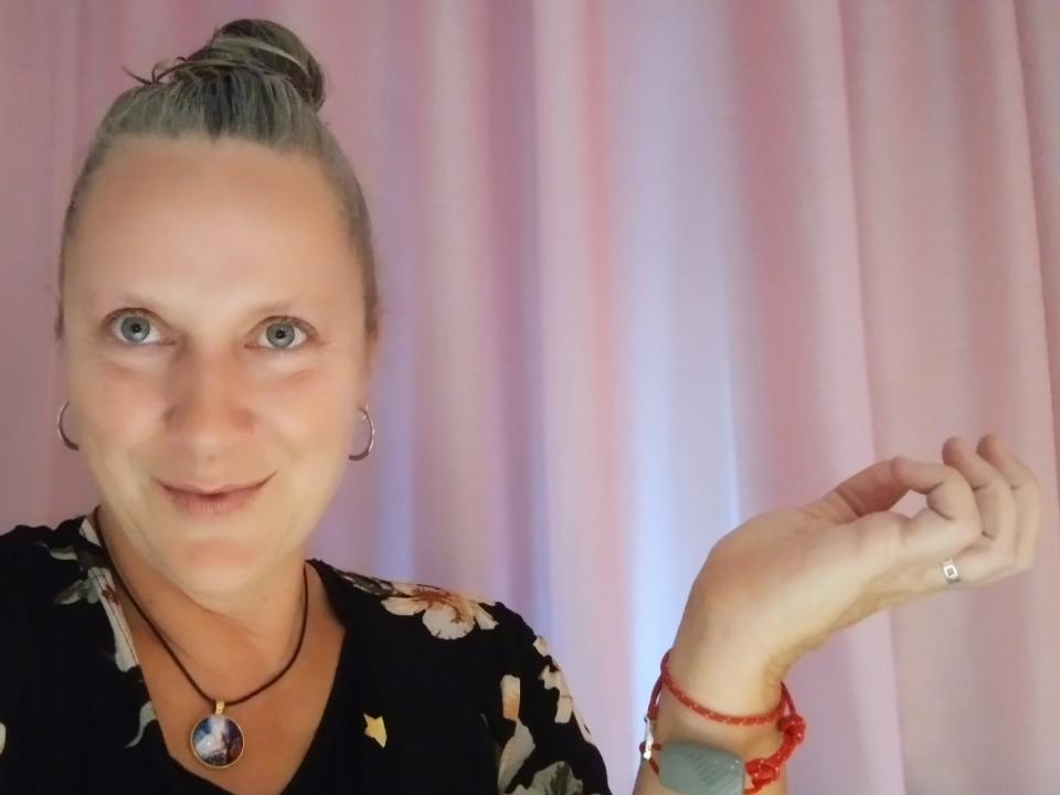 A woman showing her red bracelet.