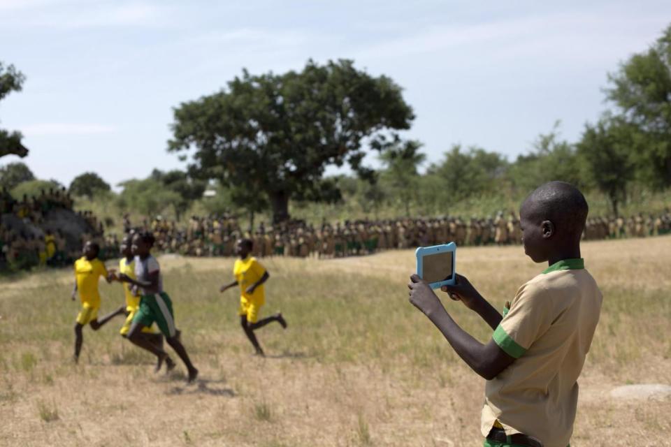 A student uses a computer tablet to record a video (UNICEF)