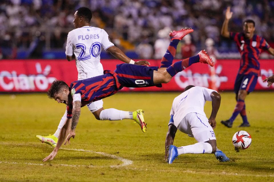 United States' Christian Pulisic, left, jumps over Honduras' Maynor Figueroa during a qualifying soccer match for the FIFA World Cup Qatar 2022 in San Pedro Sula, Honduras, Wednesday, Sept. 8, 2021. (AP Photo/Moises Castillo)
