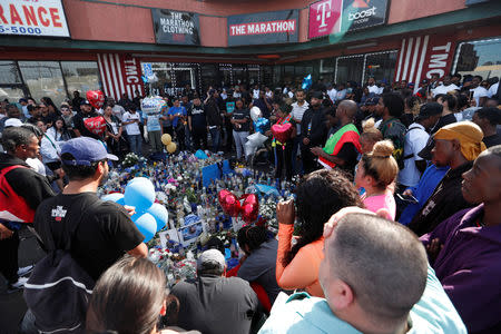 People gather around a makeshift memorial for Grammy-nominated rapper Nipsey Hussle who was shot and killed outside his clothing store in Los Angeles, California, U.S., April 1, 2019. REUTERS/Mario Anzuoni