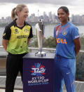 Cricket captains Meg Lanning of Australia, left, and Harmanpreet Kaur of India pose for a photo with the trophy ahead of the Women's T20 World Cup in Sydney, Monday, Feb. 17, 2020. The tournament begins with a game between Australia and India, Friday, Feb. 21. (AP Photo/Rick Rycroft)