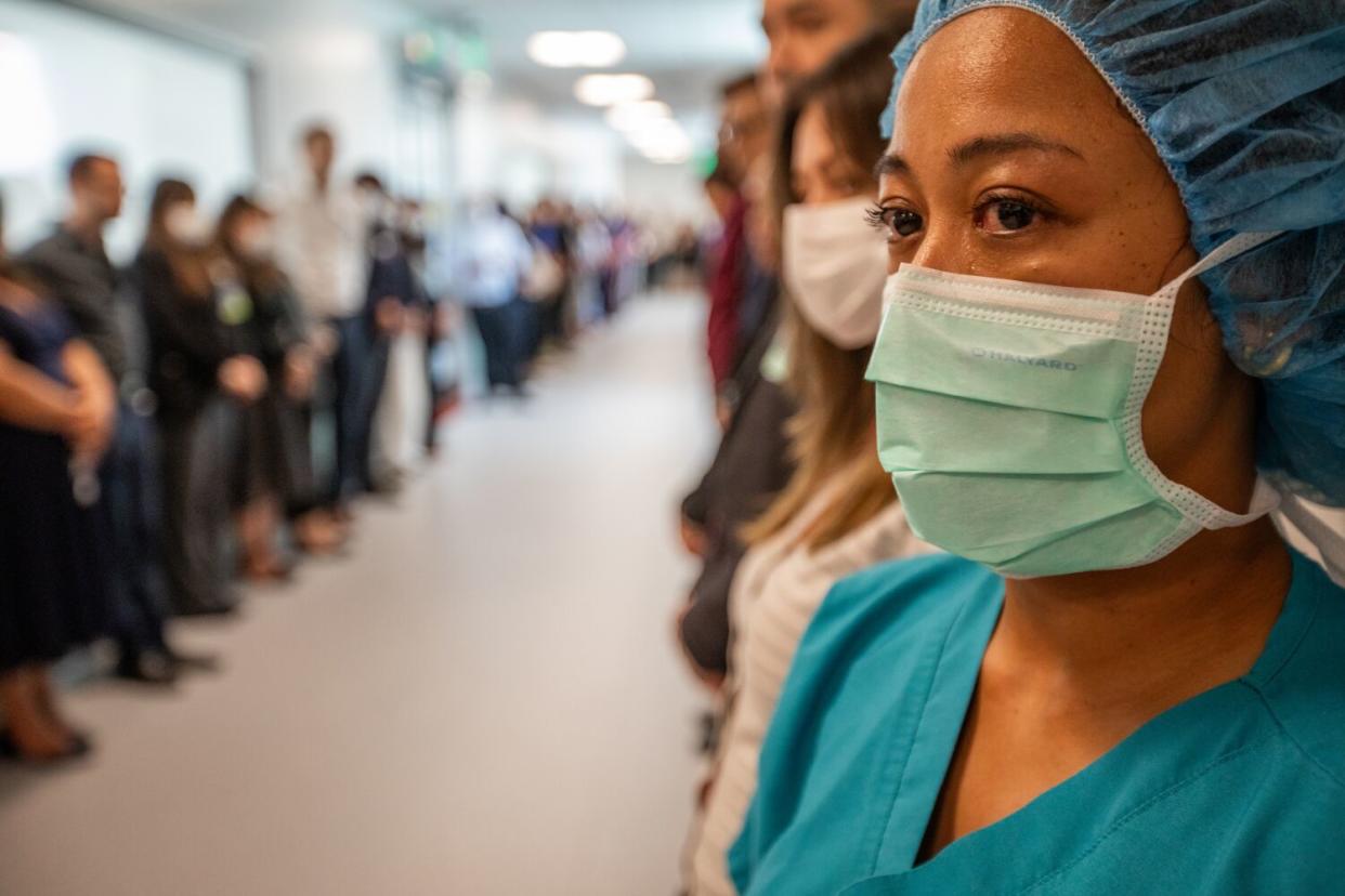 A member of OneLegacy staff cries as employees line the hallway to the operating room to honor a soon-to-be organ donor.