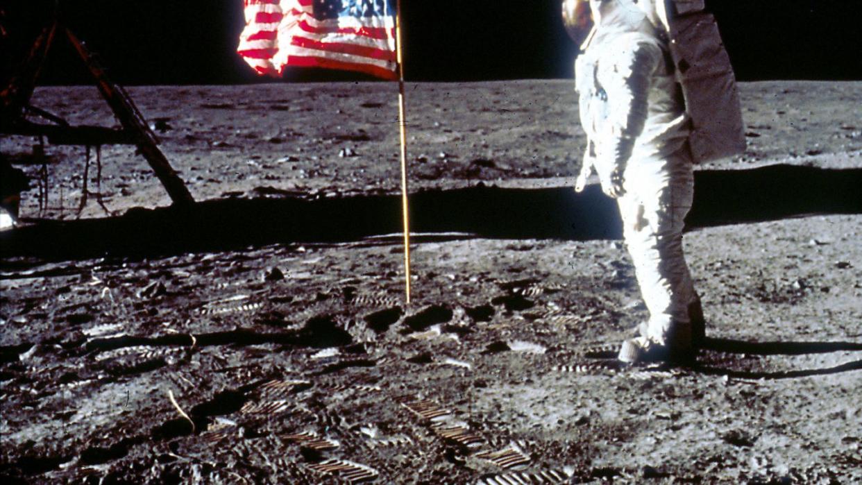 buzz aldrin poses next to the us flag on moon