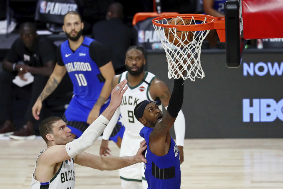 Orlando Magic guard Terrence Ross (31) shoots in front of Milwaukee Bucks center Brook Lopez (11), left, during the second half of Game 1 of an NBA basketball first-round playoff series, Tuesday, Aug. 18, 2020, in Lake Buena Vista, Fla. (Kim Klement/Pool Photo via AP)