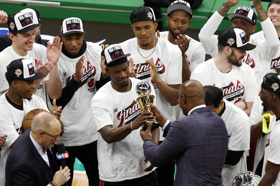 Miami Heat's Bam Adebayo, center, is presented with the the Larry Bird Trophy for most valuable player after the Heat defeated the Boston Celtics 103-84 in Game 7 of the NBA basketball Eastern Conference finals Monday, May 29, 2023, in Boston. (AP Photo/Michael Dwyer)