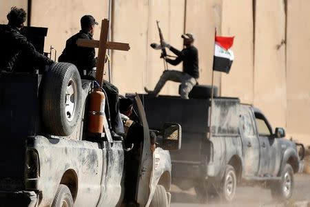 Christian fighters carry a cross on a vehicle at a check point near Bartella, Iraq, November 21, 2016. REUTERS/Goran Tomasevic