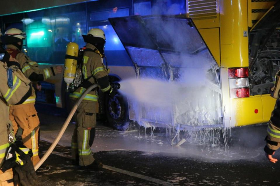 Feuerwehrleute löschen den Motor eines BVG-Busses.<span class="copyright">Morris Pudwell</span>