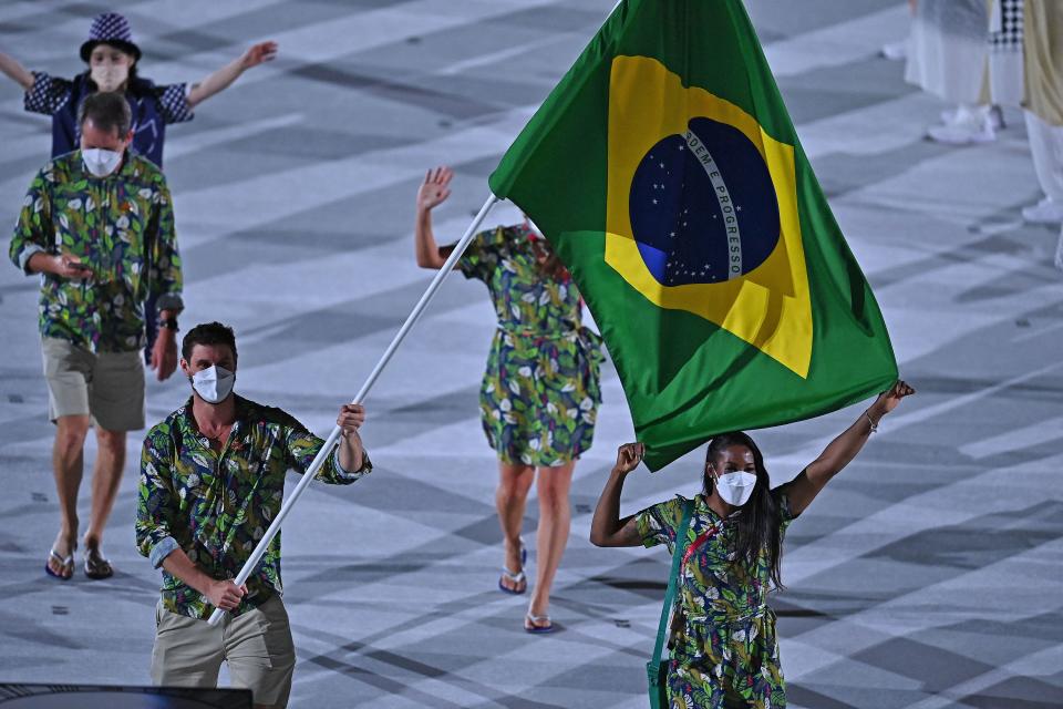 <p>Brazil's flag bearer Bruno Mossa Rezende and Brazil's flag bearer Ketleyn Quadros delegation parade during the opening ceremony of the Tokyo 2020 Olympic Games, at the Olympic Stadium, in Tokyo, on July 23, 2021. (Photo by Ben STANSALL / AFP) (Photo by BEN STANSALL/AFP via Getty Images)</p> 