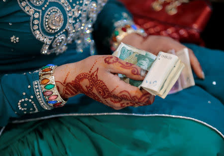 A member of the transgender community counts money she plans to throw at friends as she attends Shakeela's party in Peshawar, Pakistan January 22, 2017. REUTERS/Caren Firouz