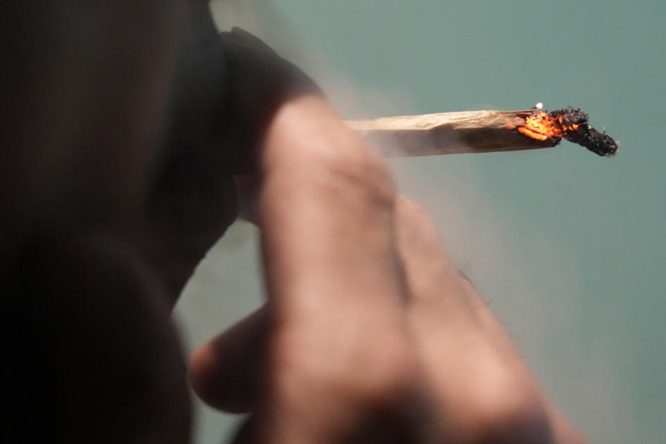 A Japanese tourist smokes cannabis at a Dutch passion shop in Bangkok, Thailand, Tuesday, June 27, 2023. Thailand’s de facto legalization of marijuana last year has brought a wave of tourists from the region intrigued by the lure of the forbidden leaf.(AP Photo/Sakchai Lalit)