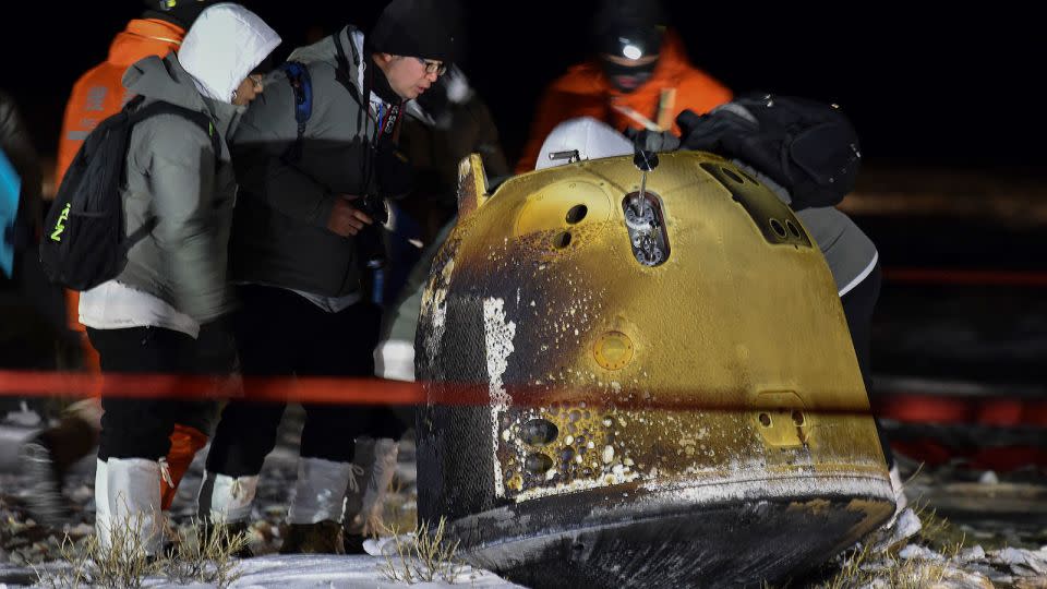 Rescue team members inspect the Chang'e 5 probe after it successfully landed in northern China in December 2020. - Ren Junchuan/Xinhua/AP/File