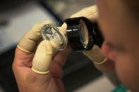 FILE PHOTO: FILE PHOTO: A quality control agent examines a silver eagle silver coin at the United States West Point Mint facility in West Point, New York