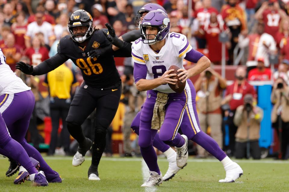 Minnesota Vikings quarterback Kirk Cousins (8) scrambles away from Washington Commanders defensive end James Smith-Williams (96) at FedExField.