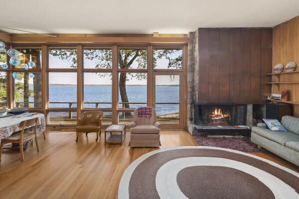 Inside, wood, glass, and stone mingle to create a timeless palette. Floor-to-ceiling windows wrap around the main living room, capturing picturesque views of Whitefish Lake.