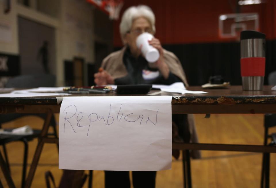 An election worker awaits voters in Stamford