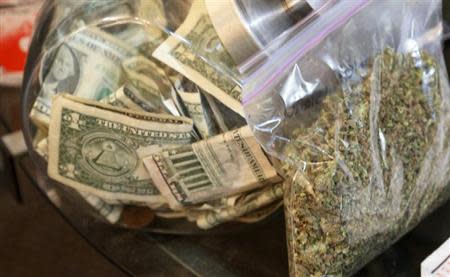 A bag of marijuana being prepared for sale sits next to a money jar at BotanaCare in Northglenn, Colorado December 31, 2013. REUTERS/Rick Wilking