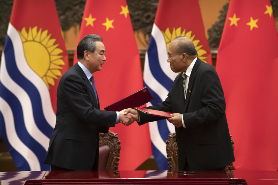 Chinese Foreign Minister Wang Yi, left, and Kiribati's President Taneti Maamau shake hands during a signing ceremony at the Great Hall of the People in Beijing, Monday, Jan. 6, 2020. (AP Photo/Mark Schiefelbein, Pool)