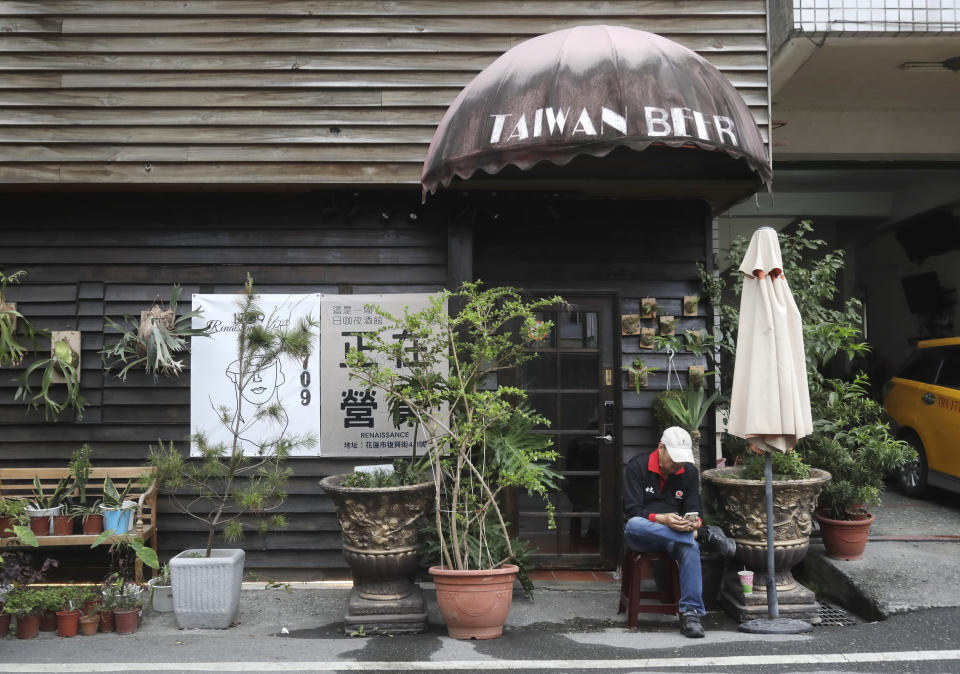 A government officer sits in front of a store closed due to the earthquake, two days after a powerful earthquake struck the city, in Hualien City, eastern Taiwan, Friday, April 5, 2024. Rescuers searched Thursday for missing people and worked to reach hundreds stranded when Taiwan's strongest earthquake in 25 years sent boulders and mud tumbling down mountainsides, blocking roads. (AP Photo/Chiang Ying-ying)