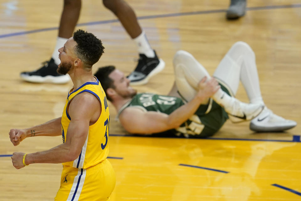 Golden State Warriors guard Stephen Curry, foreground, celebrates near Milwaukee Bucks guard Pat Connaughton after the Warriors defeated the Milwaukee Bucks in an NBA basketball game in San Francisco, Tuesday, April 6, 2021. (AP Photo/Jeff Chiu)