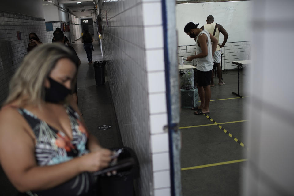 Personas sufragan en un centro de votación el domingo 29 de noviembre de 2020 durante la segunda ronda de las elecciones municipales, en Río de Janeiro, Brasil. (AP Foto/Silvia Izquierdo)