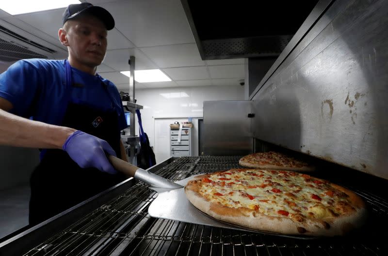 FILE PHOTO: A staff member prepares pizzas at a Domino's Pizza restaurant in Moscow