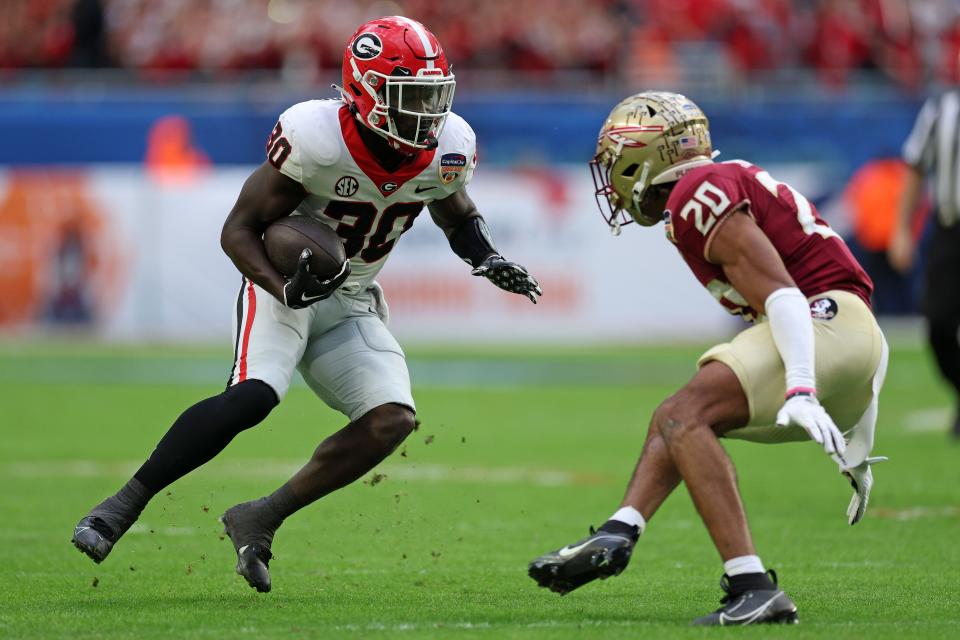 Georgia Bulldogs running back Daijun Edwards (30) rushes the ball against Florida State Seminoles defensive back Azareye'h Thomas during the first half in the 2023 Orange Bowl on December 30, 2023, at Hard Rock Stadium in Miami Gardens, Florida.