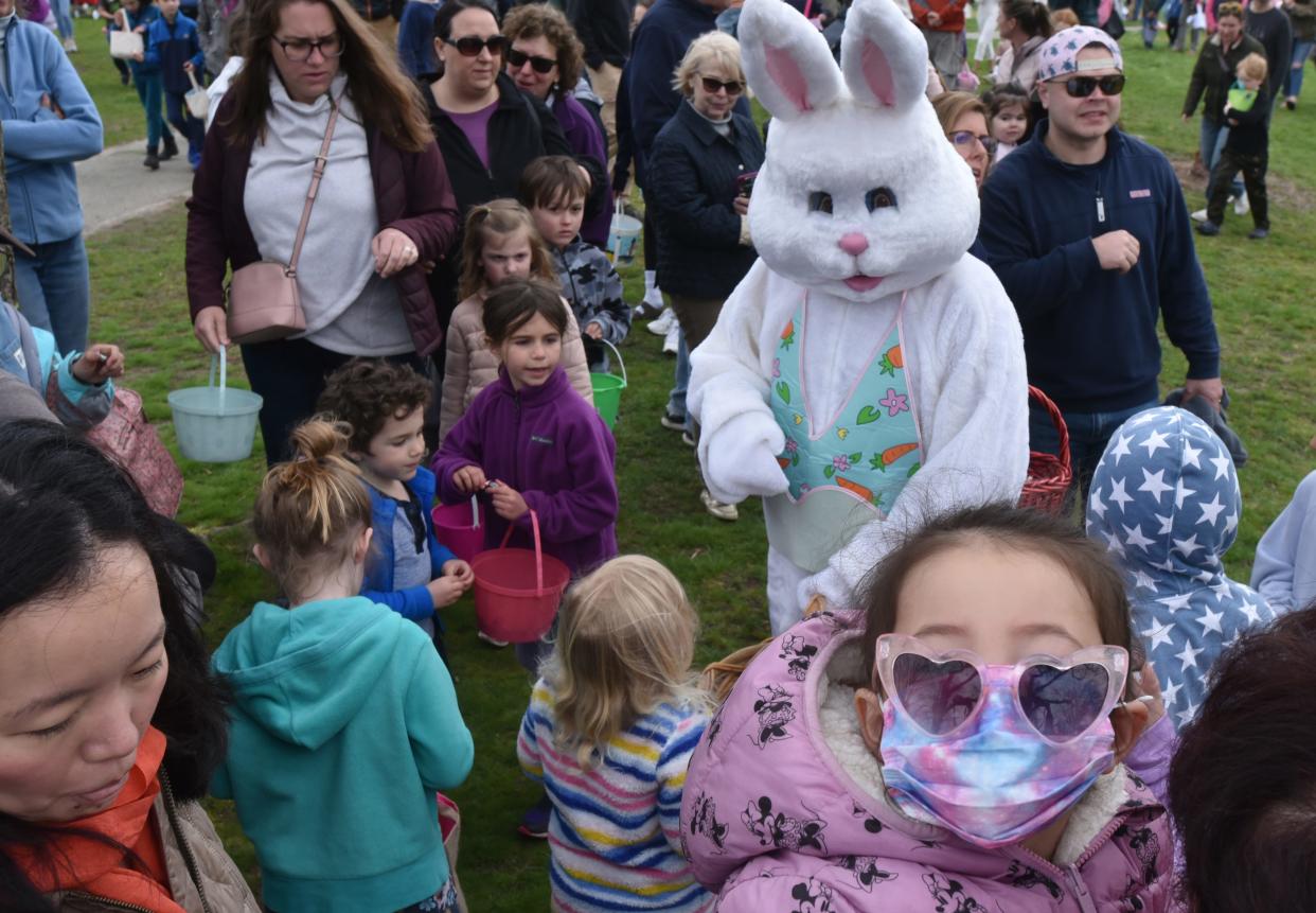 Kids and adults swamp the Easter Bunny as he makes his way through the crowd restocking kid's baskets at the Kate Gould Park in Chatham where the town's annual Easter egg hunt returned in 2022 after a pandemic pause.