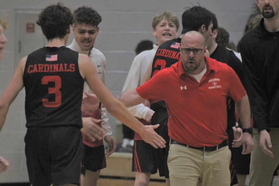 Onaway boys basketball coach Eddy Szymoniak congratulates junior Mason Beebe (3) after Beebe nailed a 3-pointer that forced an Inland Lakes timeout during the fourth quarter on Friday night.