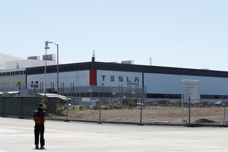 A man walks towards the Tesla factory in Fremont, California, U.S. June 22, 2018. REUTERS/Stephen Lam