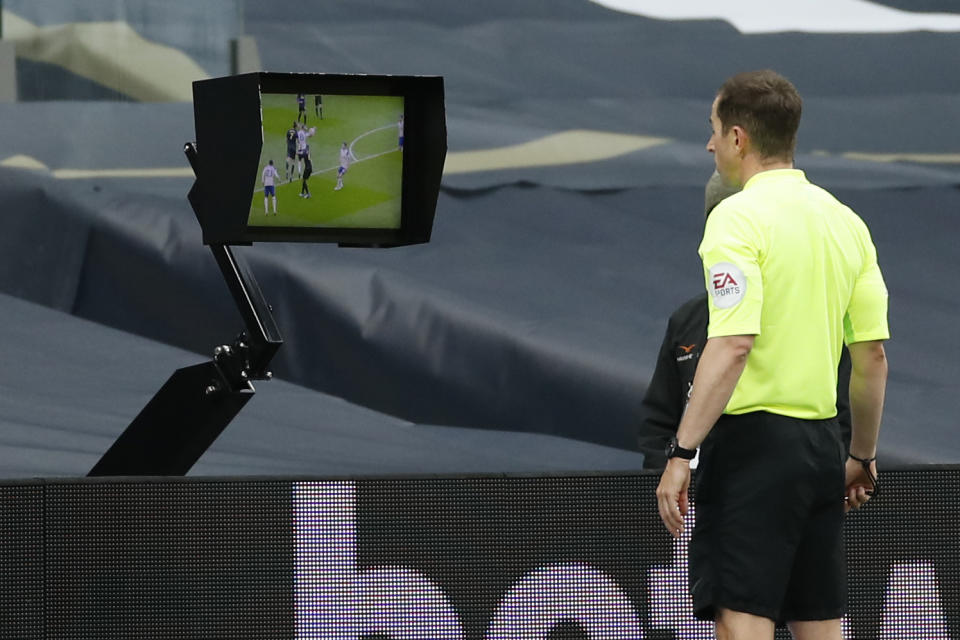 El árbitro Peter Bankes observa un monitor durante el partido Newcastle-Tottenham por la Liga Premier inglesa, el domingo 27 de septimbre de 2020, en Londres. (Andrew Boyers/Pool vía AP)