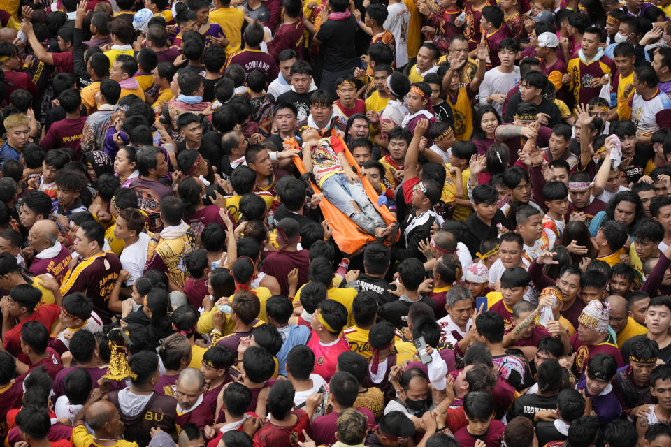 A devotee is taken away on a stretcher after being injured during the annual Black Nazarene procession which was resumed after a three-year suspension due to the coronavirus pandemic on Tuesday, Jan. 9, 2024 in Manila, Philippines. A mammoth crowd of mostly barefoot Catholic devotees joined a chaotic procession through downtown Manila Tuesday to venerate a centuries-old black statue of Jesus Christ with many praying for peace in the Middle East where Filipino relatives work. (AP Photo/Aaron Favila)