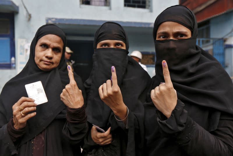 FILE PHOTO: Muslim women display their inked fingers after casting their votes during the third phase of West Bengal Assembly elections in Kolkata