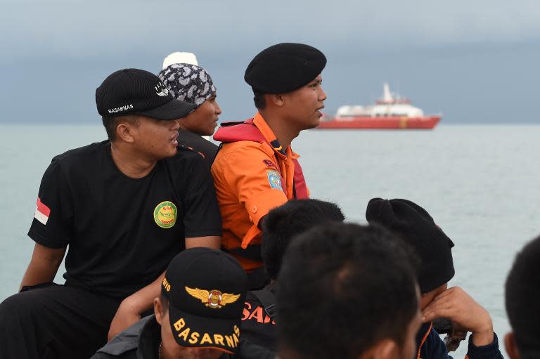 Members of an Indonesian search and rescue team are ferried out to a ship to conduct search operations at sea for missing AirAsia flight QZ8501 from Manggar in East Belitung