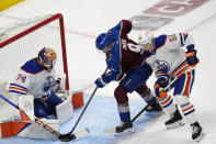 Colorado Avalanche left wing Zach Parise, center, puts a shot on Edmonton Oilers goaltender Stuart Skinner, left, after driving past defenseman Troy Stecher during the first period of an NHL hockey game Thursday, April 18, 2024, in Denver. (AP Photo/David Zalubowski)