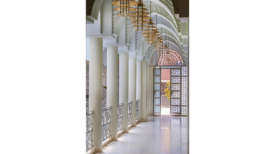 A corridor, with copper light fixtures commissioned from Italian designer Attilio Ladina. The floor is made of cement and marble powder with inserts of Carrara marble. - Credit: Jean Cazals