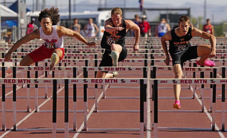 (L-R) Mountain View's Dionys Cesar, Red Mountain's Cole Rowley and Gilbert's Vance Nilsson race in the 110-meter hurdles during the track and field championships at Red Mountain High School in Mesa on May 6, 2023.