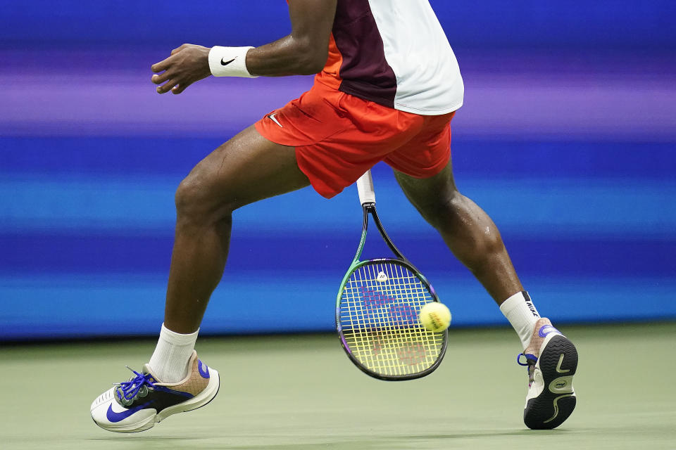 Frances Tiafoe, of the United States, returns a shot between his legs to Carlos Alcaraz, of Spain, during the semifinals of the U.S. Open tennis championships, Friday, Sept. 9, 2022, in New York. (AP Photo/Charles Krupa)