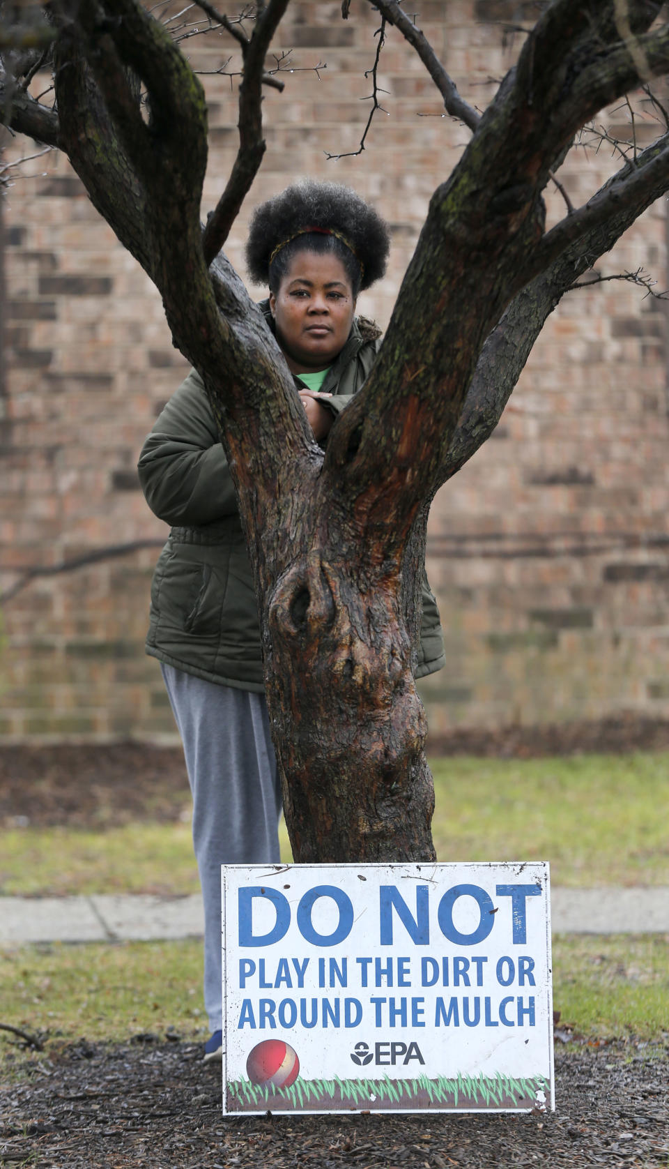 In this Thursday, March 30, 2017, photo, Tara Adams poses for a portrait outside her home as she tries to organize a move from the East Chicago, Ind., dwelling. Adams is one of dozens of families in this former industrial town who have yet to be evacuated from a housing project ordered emptied by the mayor because of severe lead contamination.(AP Photo/Charles Rex Arbogast)