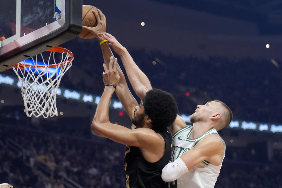 Cleveland Cavaliers center Jarrett Allen, left, is fouled by Boston Celtics center Kristaps Porzingis, right, in the first half of an NBA basketball game, Tuesday, March 5, 2024, in Cleveland. (AP Photo/Sue Ogrocki)