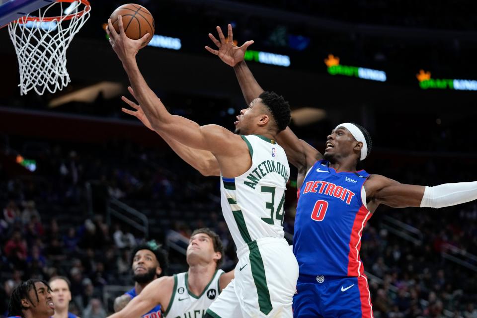 Bucks forward Giannis Antetokounmpo, who returned to action after a five-game absence, floats to the basket past Pistons center Jalen Duren for two of his team-high 29 points Monday night.